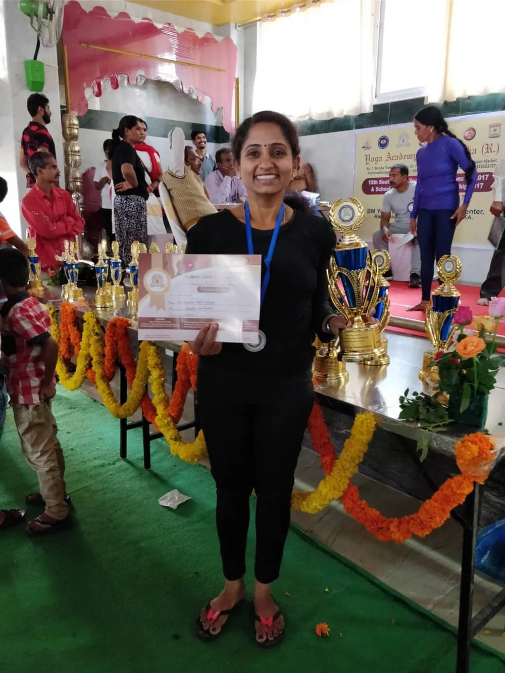 Dr. Sumitra M Patil holding her certificate from the 15th South Indian Yogasana Championship, December 2017
